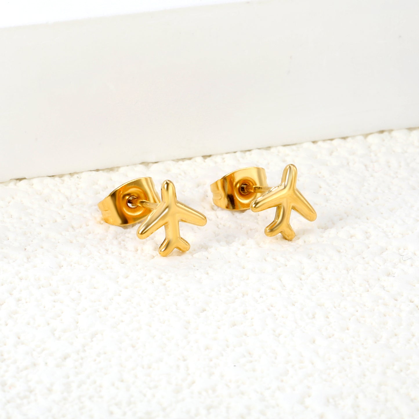 Wholesale Stainless Steel 18K Gold Plated Airplane Plain Pin EarringsClose-up of the light-colored ambiance