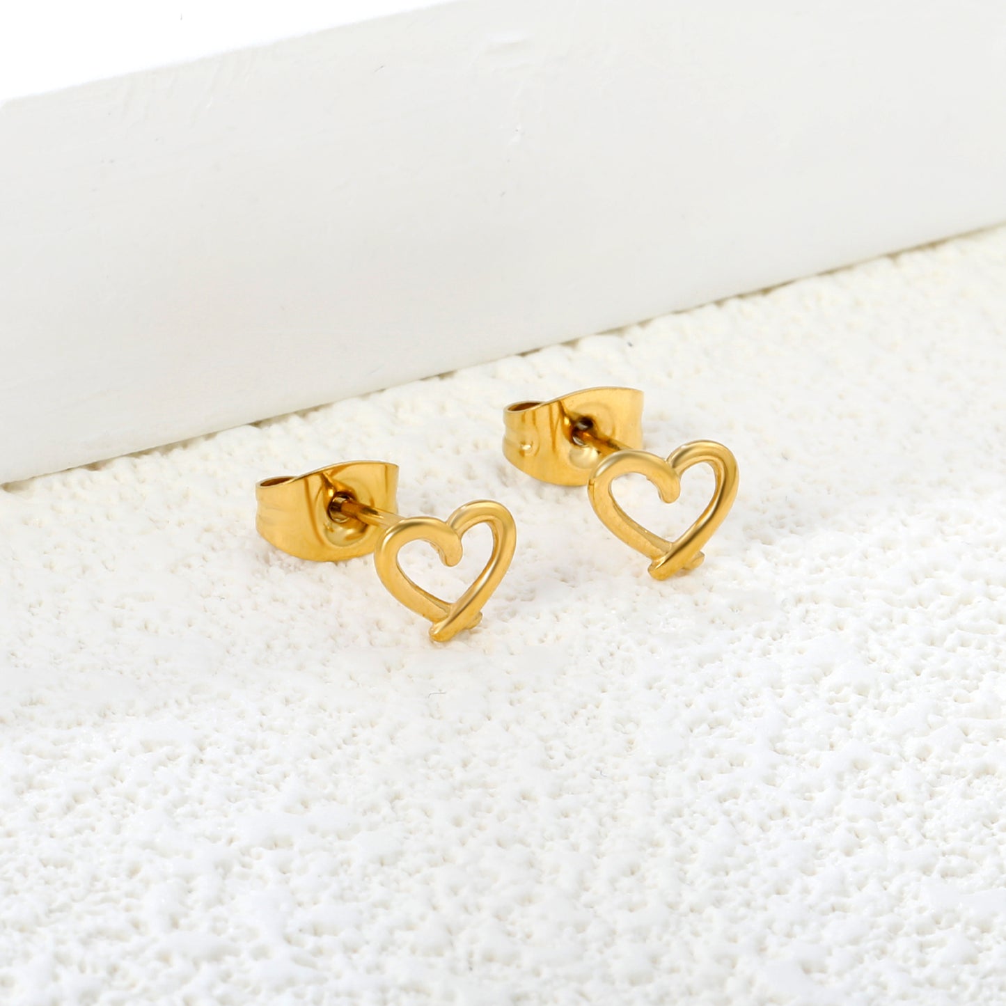Wholesale Stainless Steel 18K Gold Plated Heart Shape Openwork Plain Pin EarringsClose-up of the light-colored ambiance