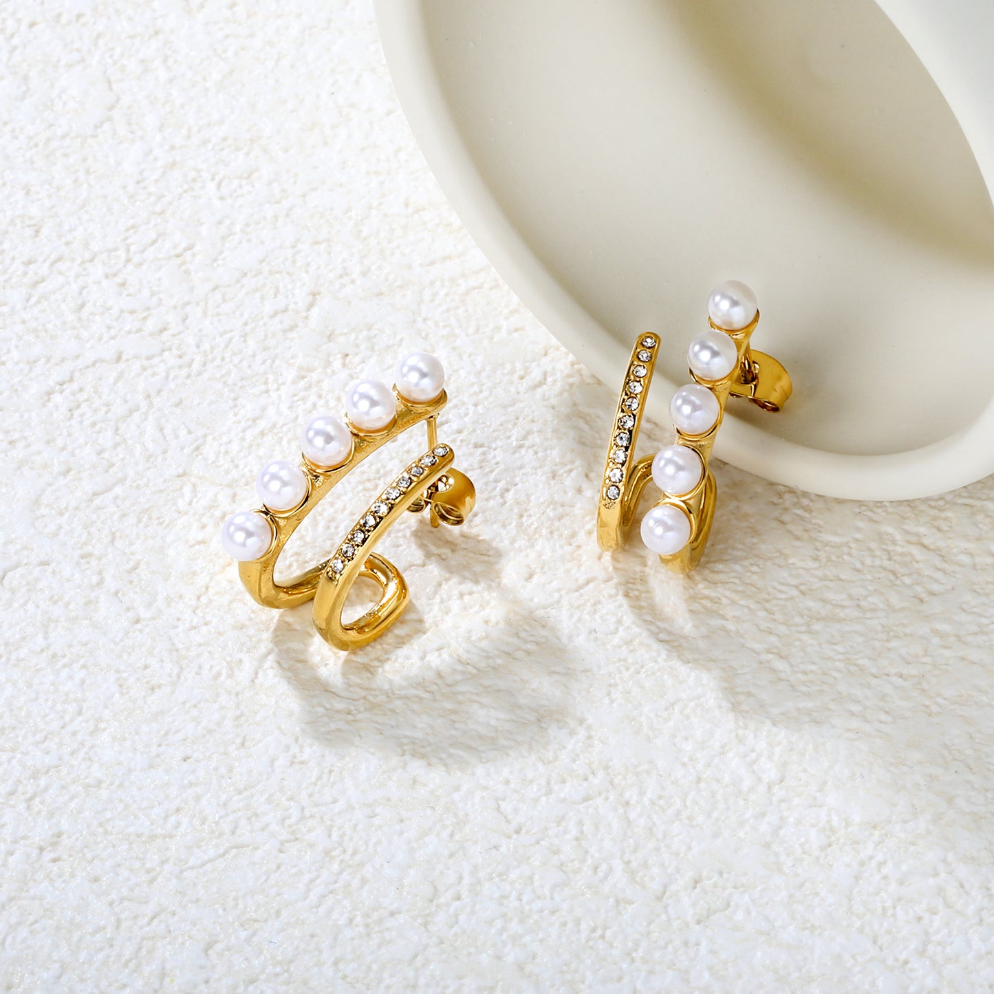 Wholesale Waterproof PVD Gold Plated Initial D Pearl Drop EarringsClose-up of the light-colored ambiance