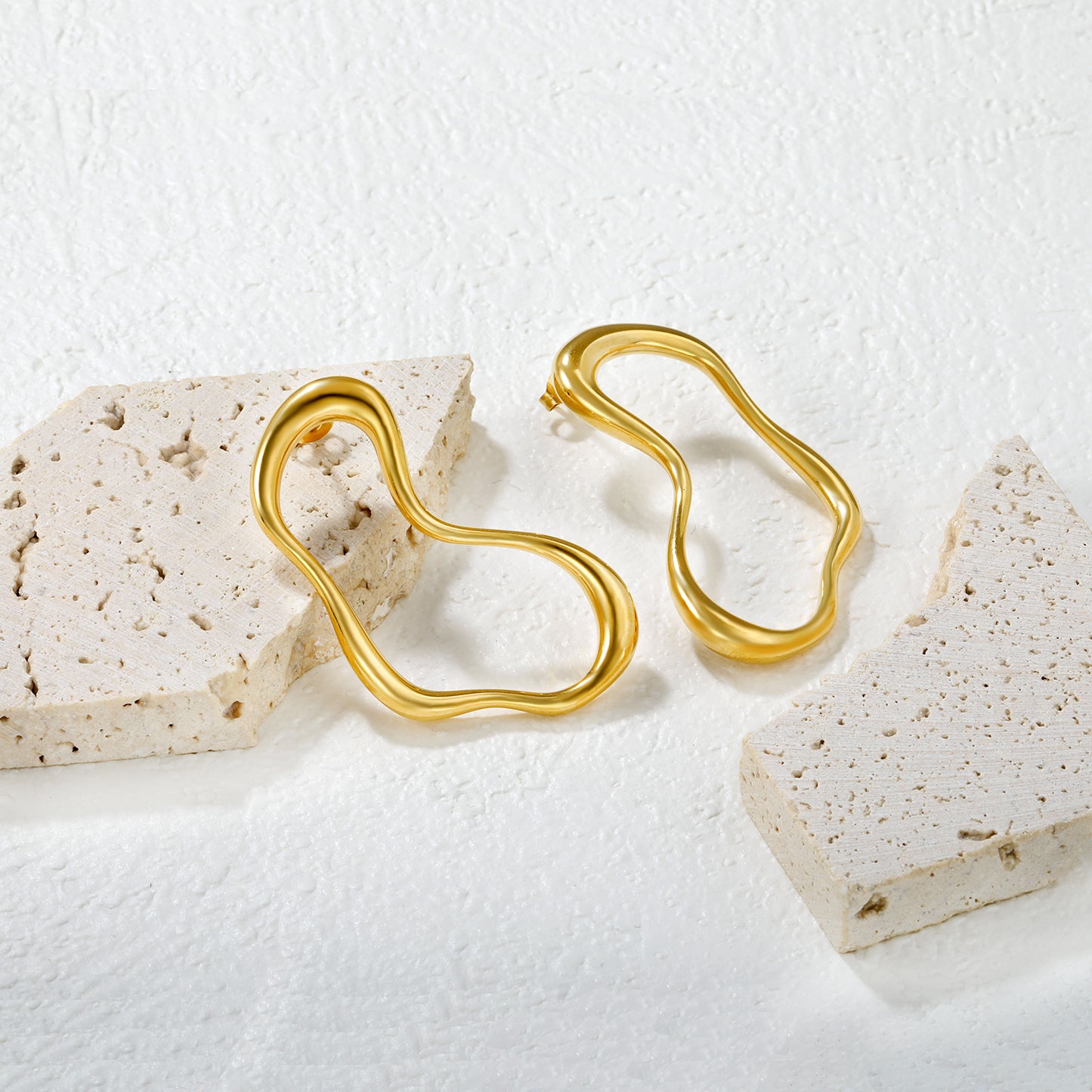 Wholesale 18K Gold Plated Irregular Wave Earrings Futuristic Art MinimalistClose-up of the light-colored ambiance