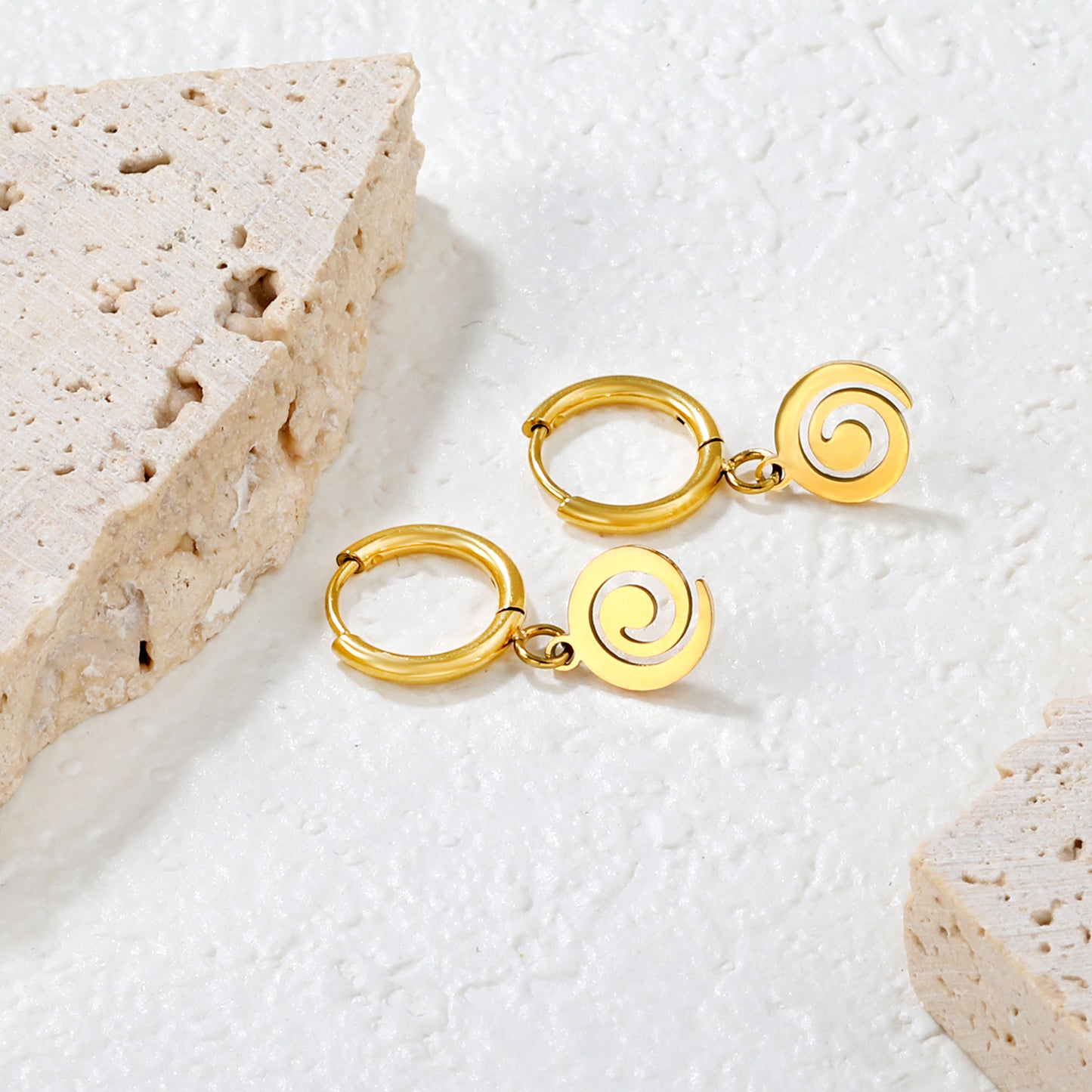 Wholesale 18K gold-plated spiral disc hoop earrings, vintage-inspired, minimalist styleClose-up of the light-colored ambiance