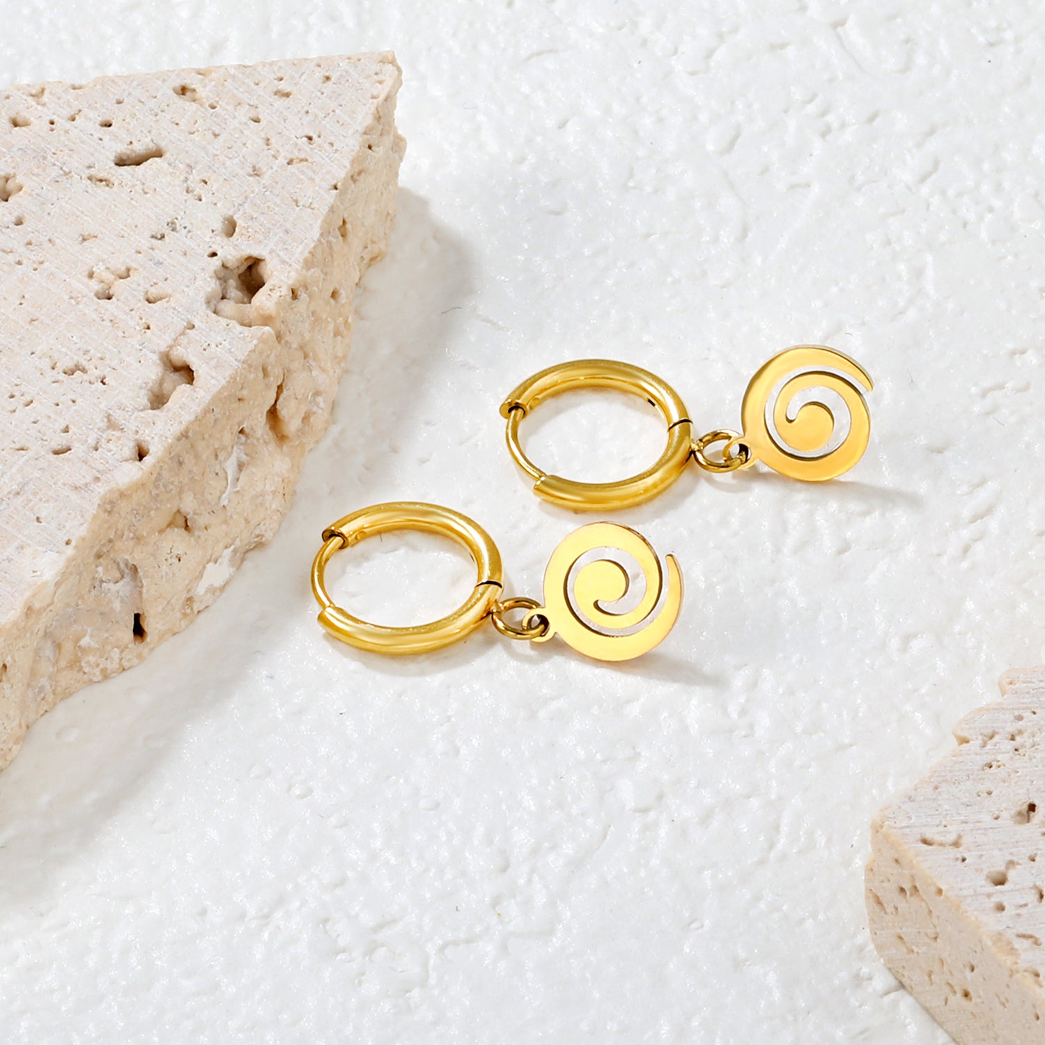 Wholesale 18K gold-plated spiral disc hoop earrings, vintage-inspired, minimalist styleClose-up of the light-colored ambiance