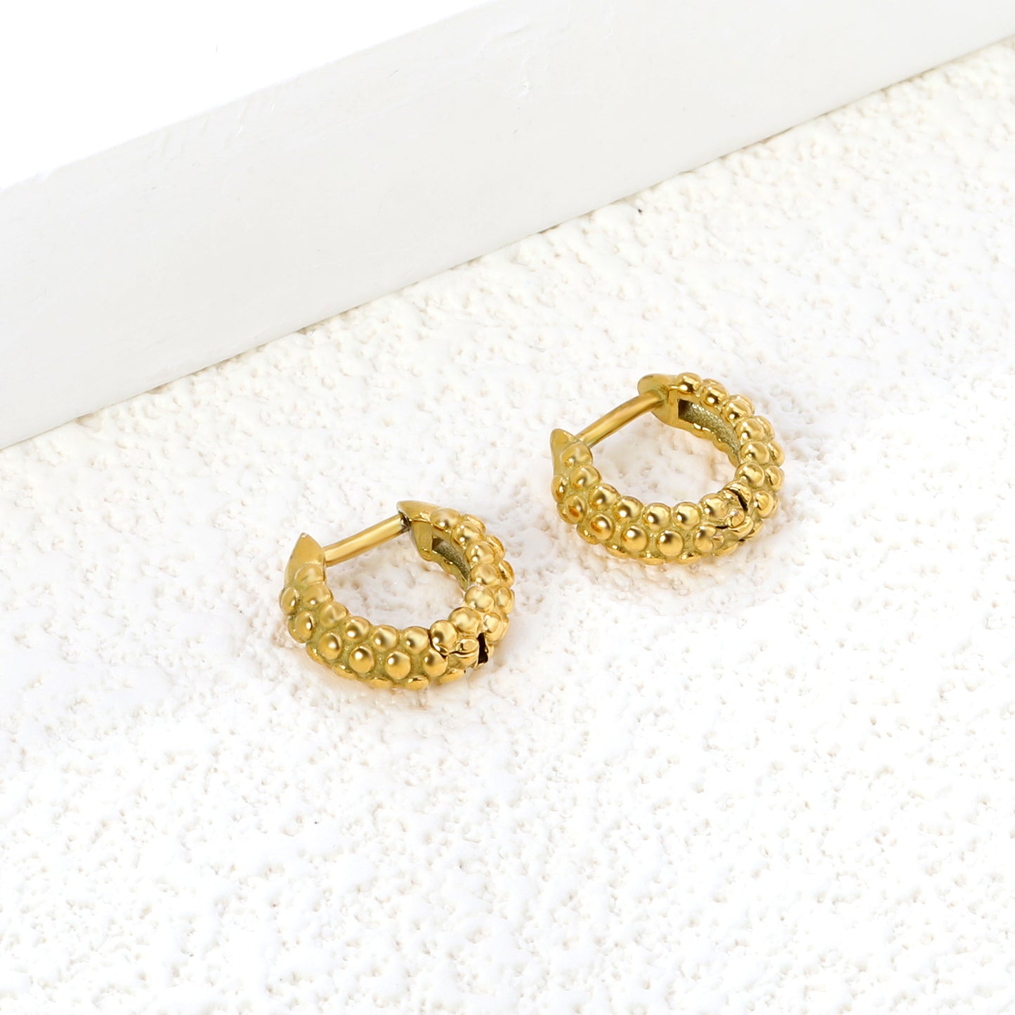 Wholesale Stainless Steel 18K Gold Plated Dimpled Round Stud EarringsClose-up of the light-colored ambiance