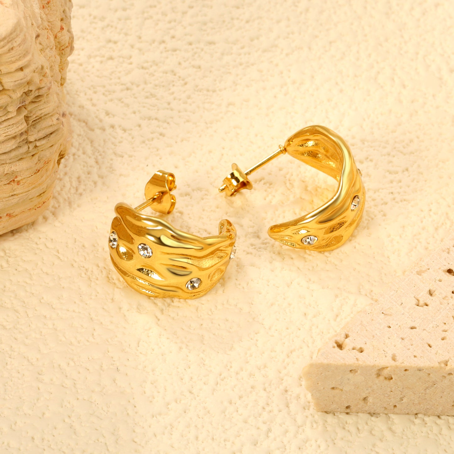 Wholesale Stainless Steel 18K Gold Plated Irregular Pattern C Shape Open Stud Earrings with Sticky White DiamondsClose-up of the light-colored ambiance