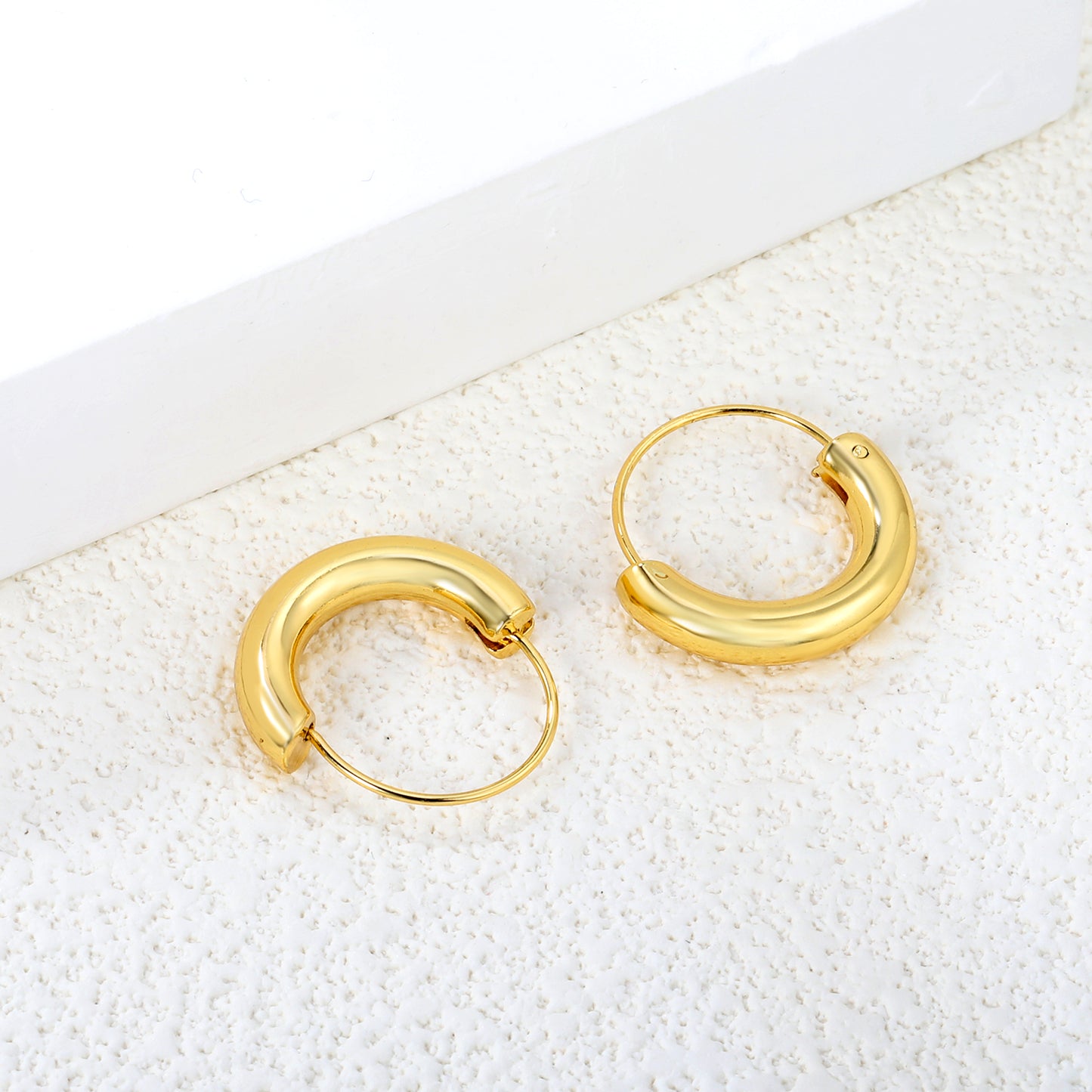 Wholesale Stainless Steel 18K Gold Plated Semi-circular Pendant Stud EarringsClose-up of the light-colored ambiance