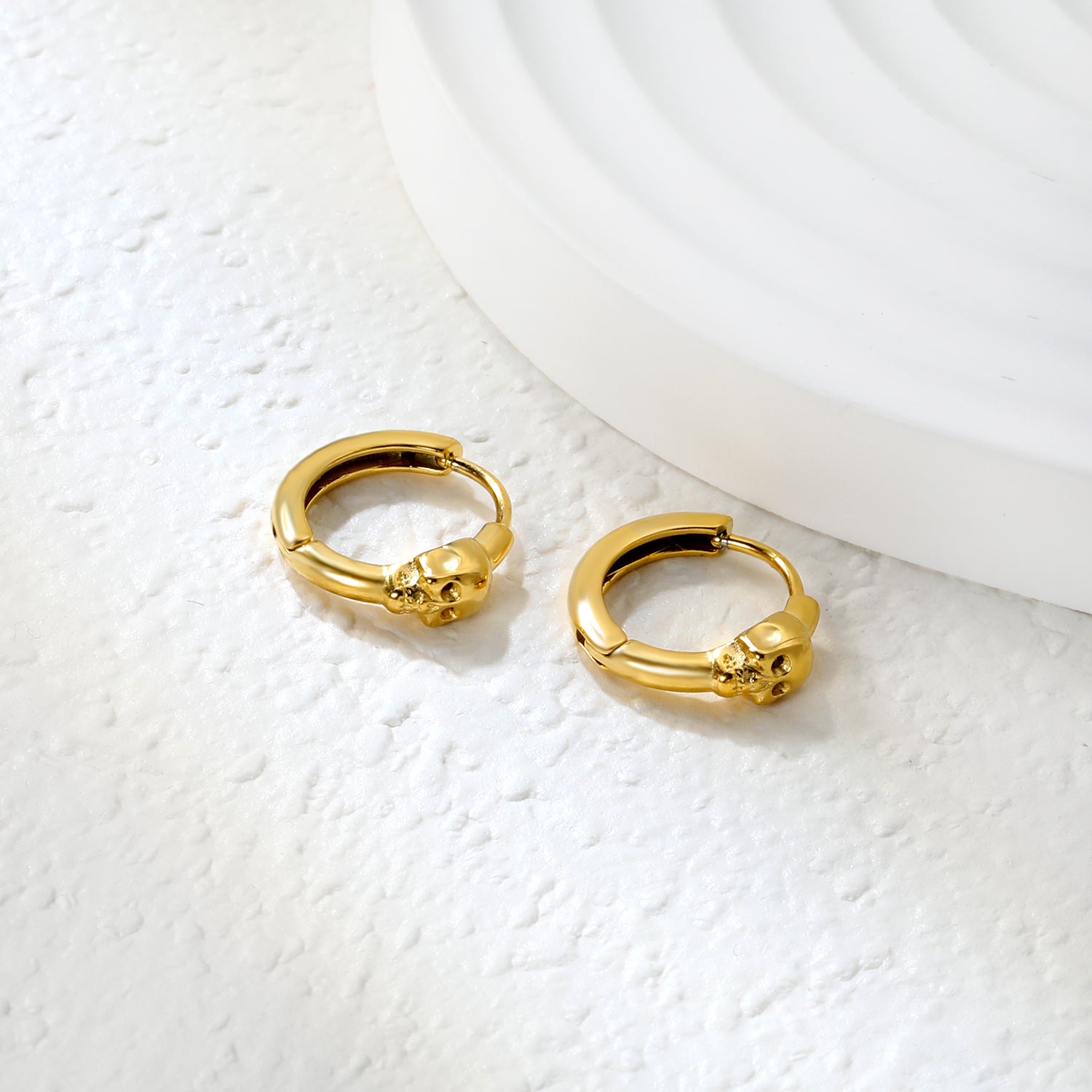 Wholesale Stainless Steel 18K Gold Plated Skull Glossy Stud EarringsClose-up of the light-colored ambiance