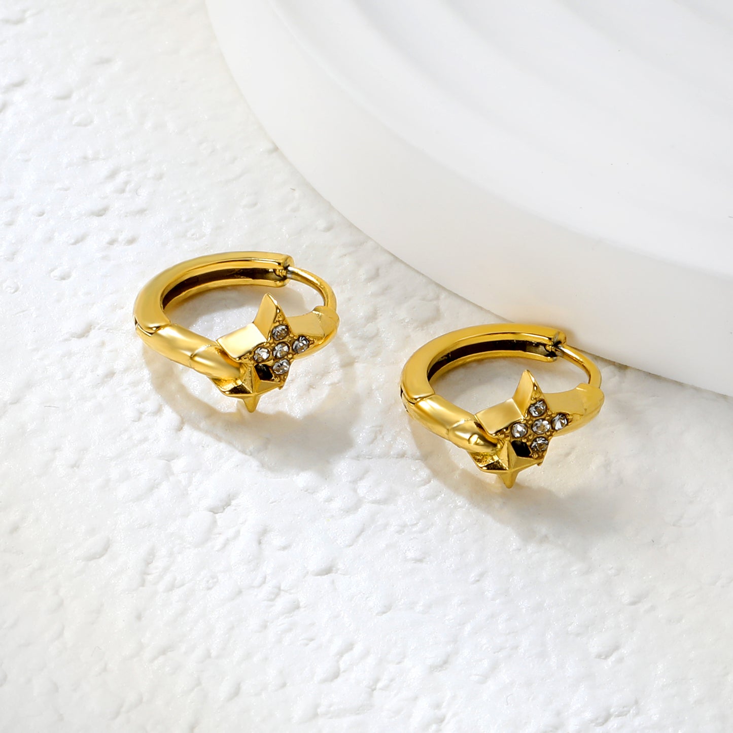 Wholesale Stainless Steel Modern Four-Point Star CZ Hoop EarringsClose-up of the light-colored ambiance