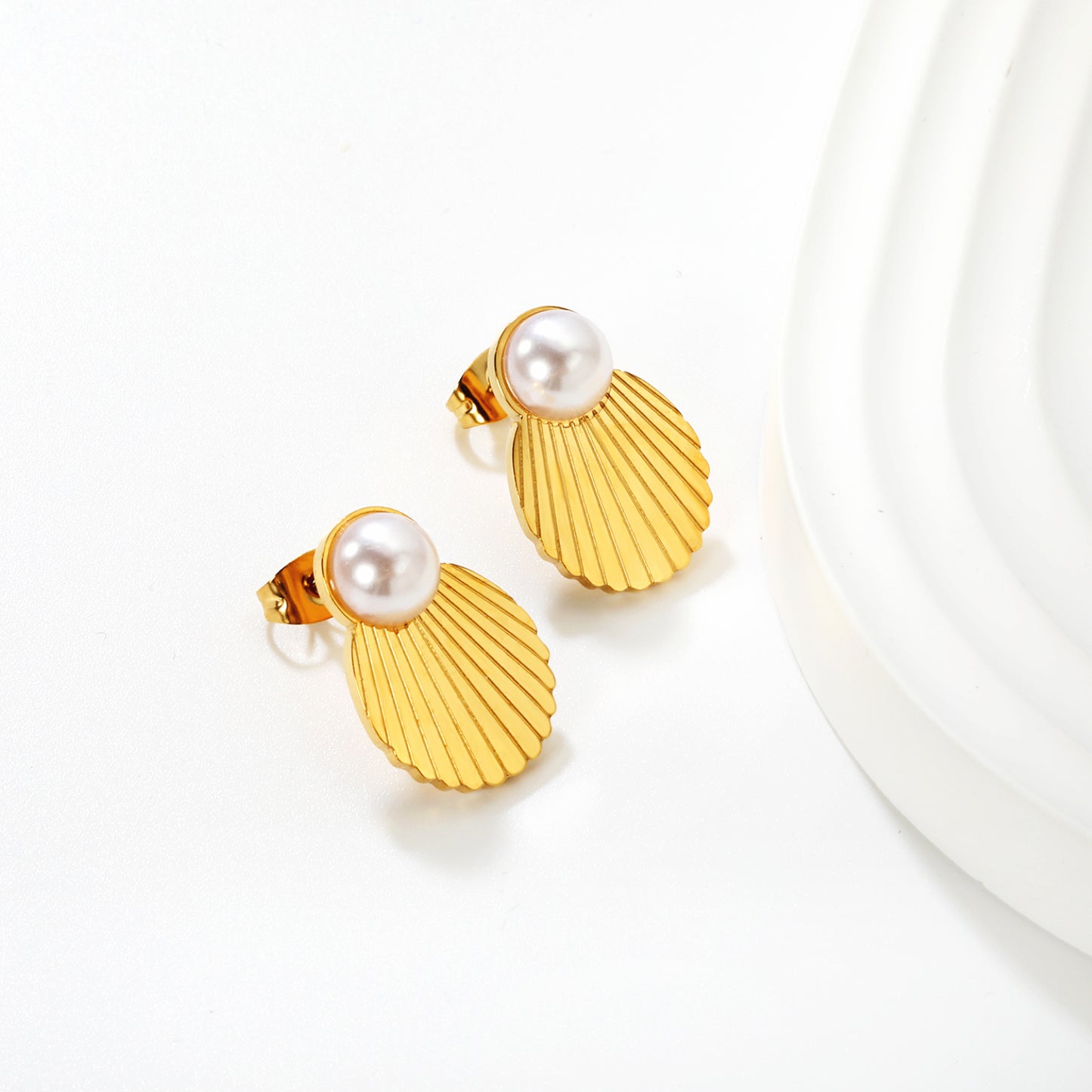 Wholesale Waterproof PVD Gold Plated Textured Seashell Pearl StudsClose-up of the light-colored ambiance