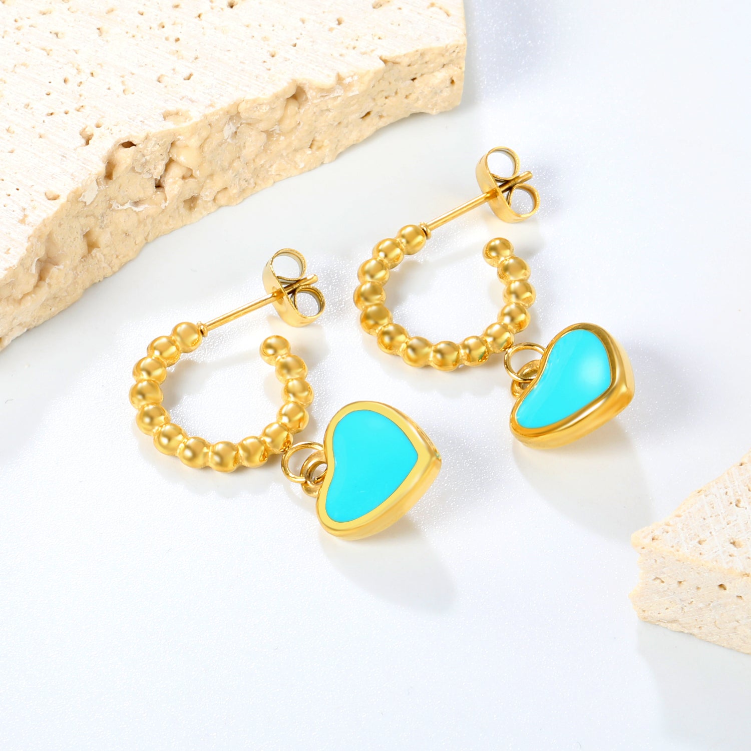 Golden blue oil drop peach heart + semi-circular steel bead stud earrings jewelry supplier lifestyle beige scene photo