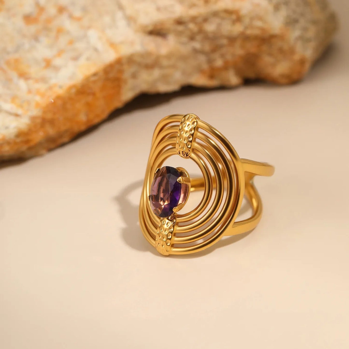 Striking Contrast Between Rough Textured Gold and Smooth Faceted Gemstone