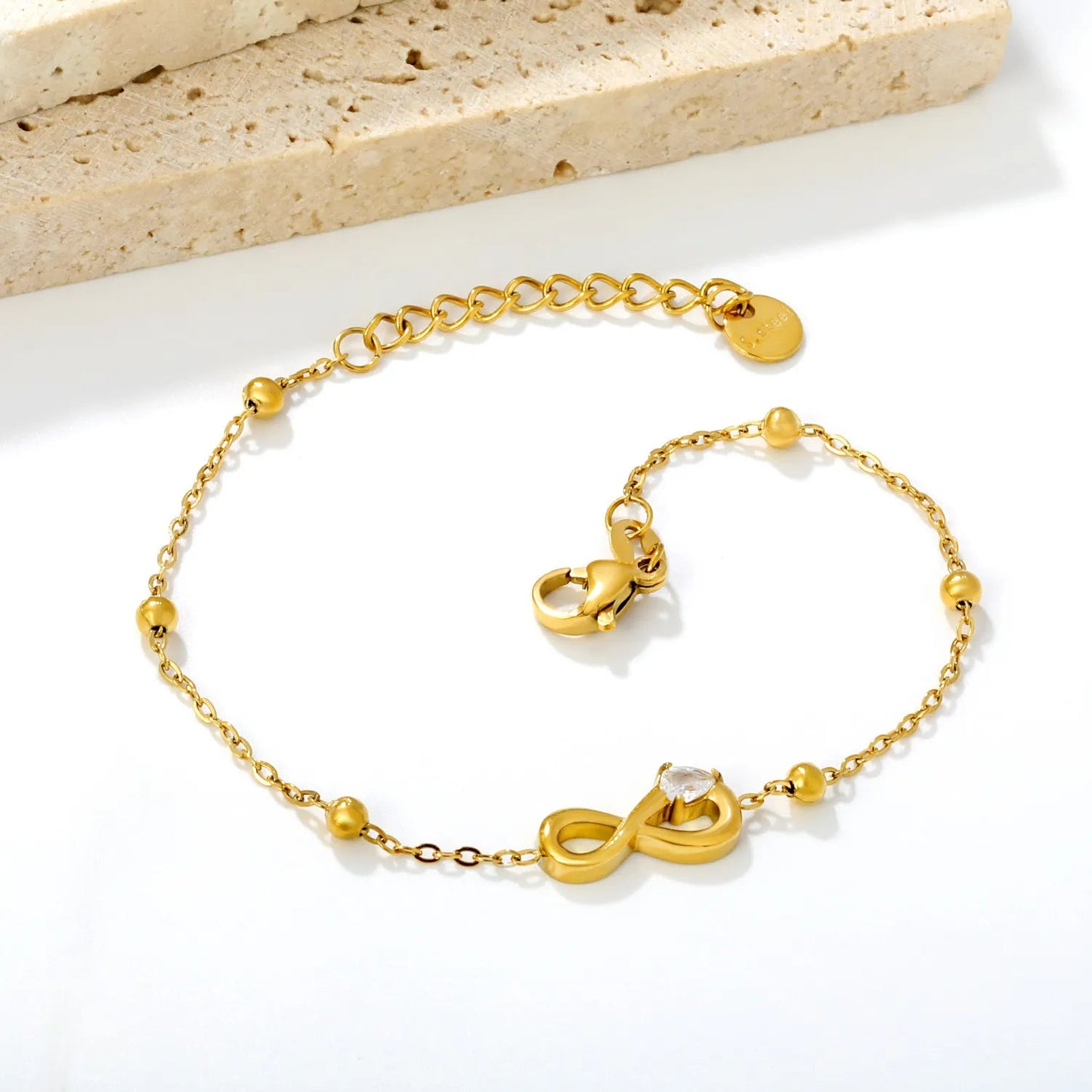 A Modern Twist on Classic Infinity Jewelry Featuring a Solitaire Drop Stone