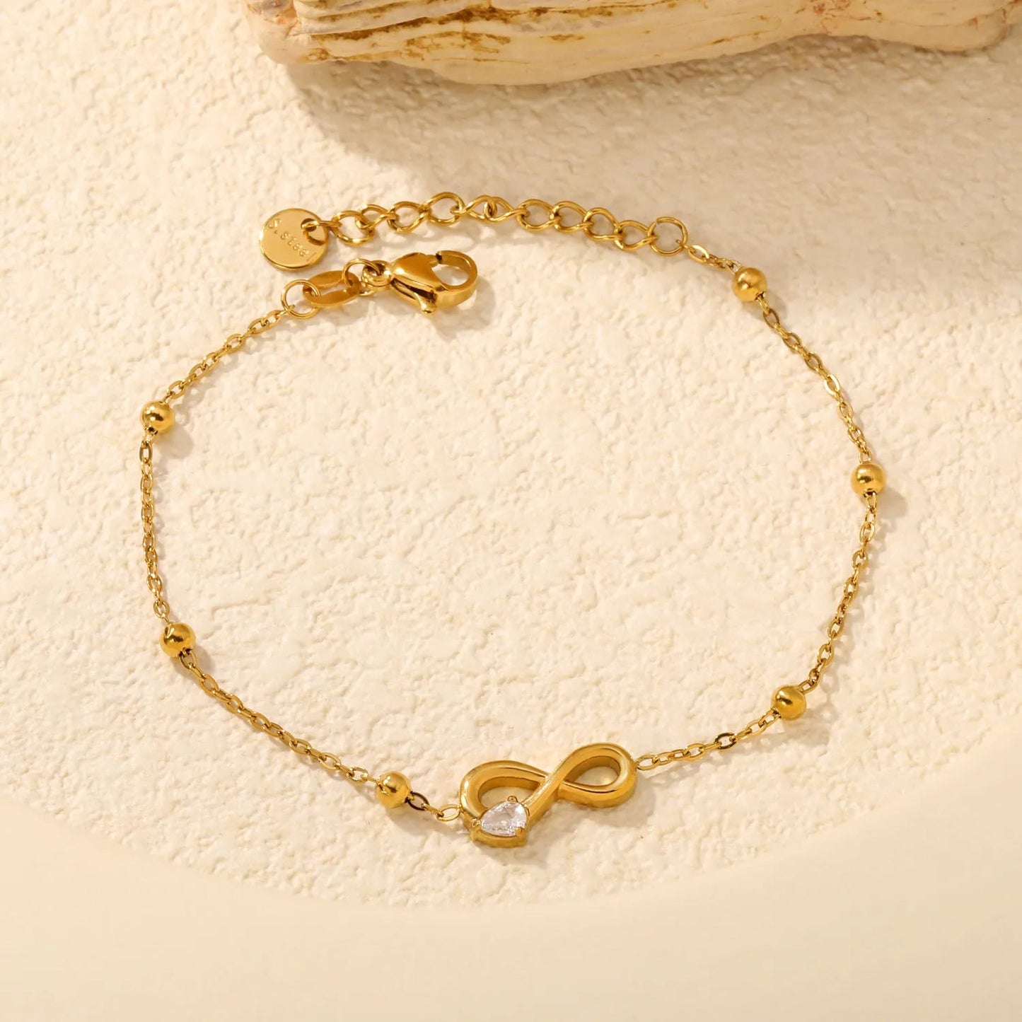 A Modern Twist on Classic Infinity Jewelry Featuring a Solitaire Drop Stone